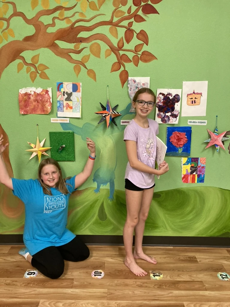 Two young artists celebrating in front of their work on the ArtHaus gallery wall