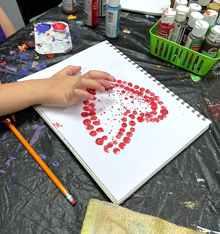 A dot-painted red heart made in an ArtHaus class