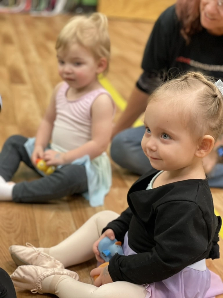 Toddlers holding egg shakers in a Bravo Babies music and movement class
