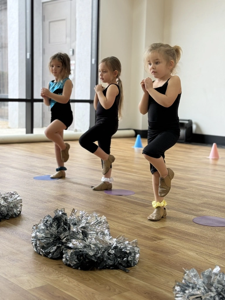 Little campers balancing in passé during a cheer camp class