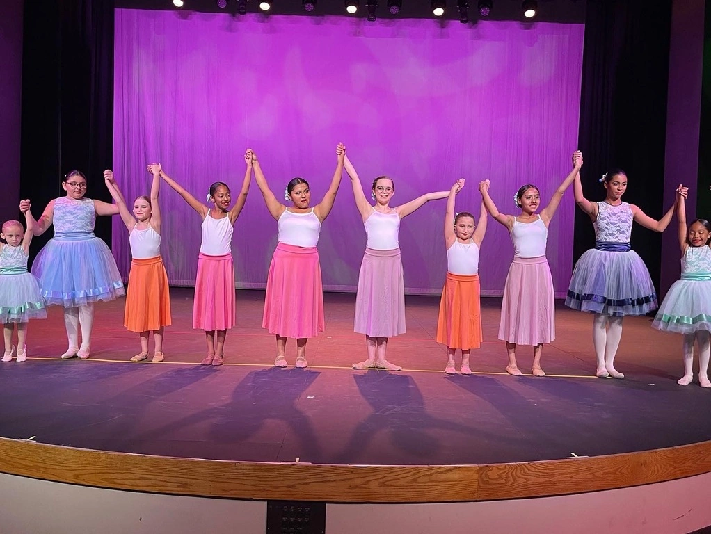The company holding hands for a bow after a ballet number