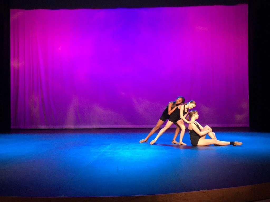 A company trio performing a contemporary piece in black