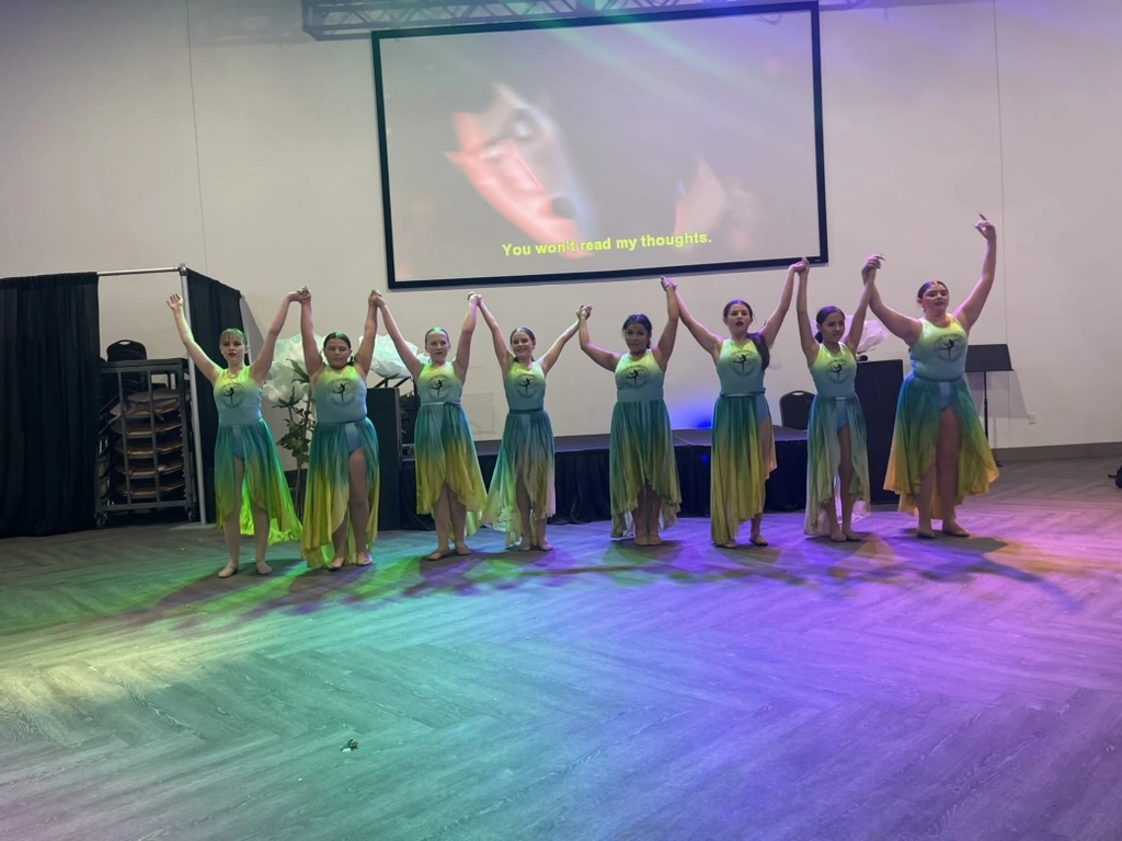 The Movement Dance Company taking a bow in ombre green and yellow lyrical dresses