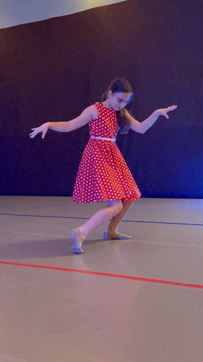 A company dancer in a red polka dot dress performing a solo