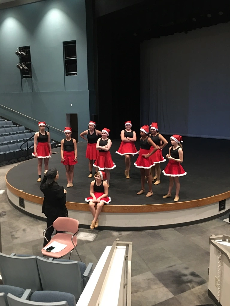The Movement Dance Company rehearsing a holiday number in Santa skirts