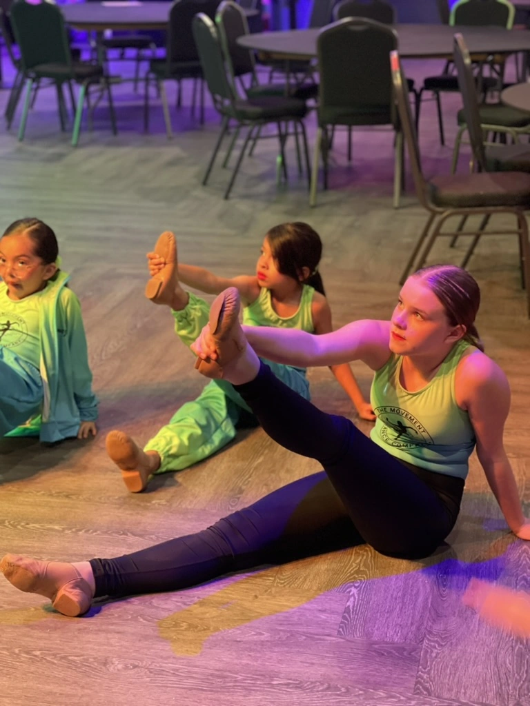 Company dancers stretching together before a performance