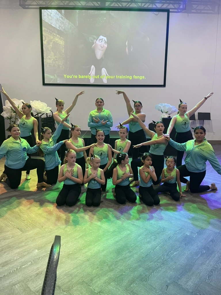 The Movement Dance Company posing in teal company tops
