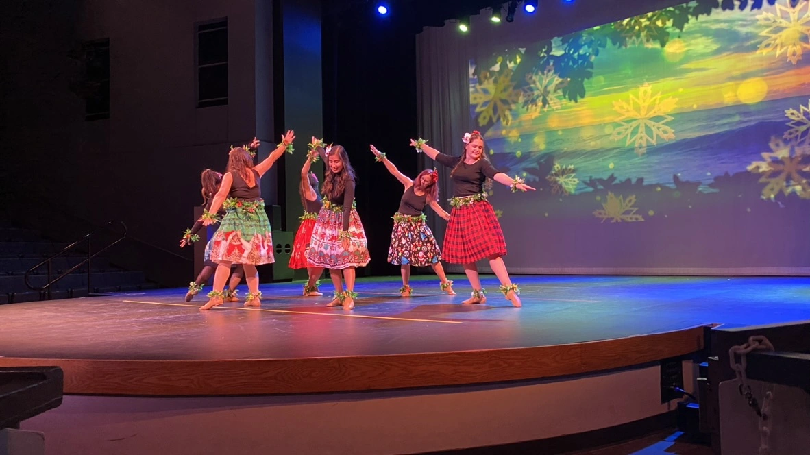 Adult Encore dancers in festive skirts dancing on stage
