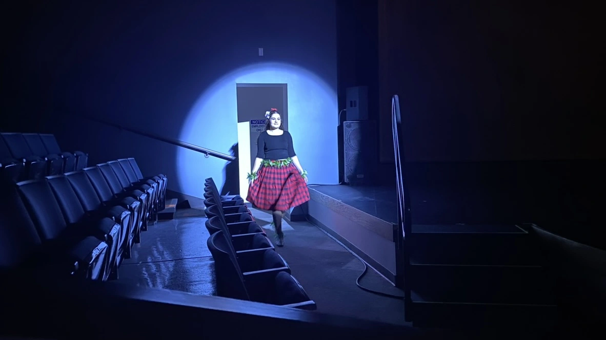 An Encore adult dancer making her entrance in a spotlight