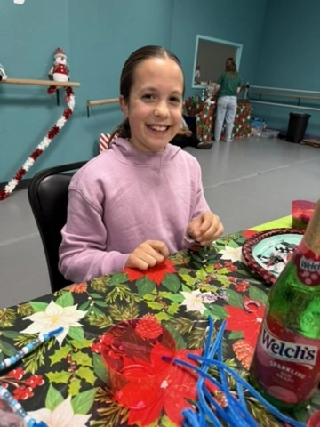 A smiling dancer at a festive Movement holiday party table
