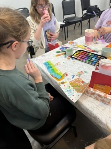 Dancers painting watercolor holiday cards at a Movement event