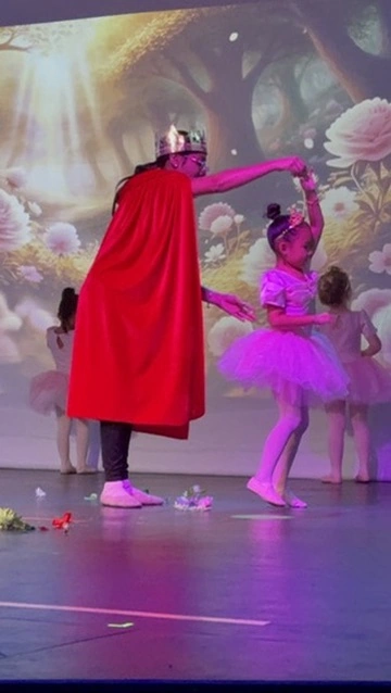 A storybook king twirls a little princess in pink on the Ovation Theatre stage at Once Upon A Ballet