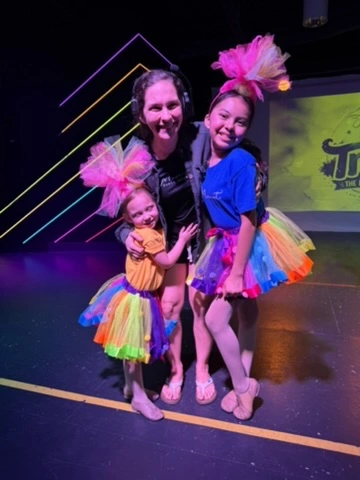 A Spotlight Academy teacher with two performers in Trolls costumes at Ovation Theatre
